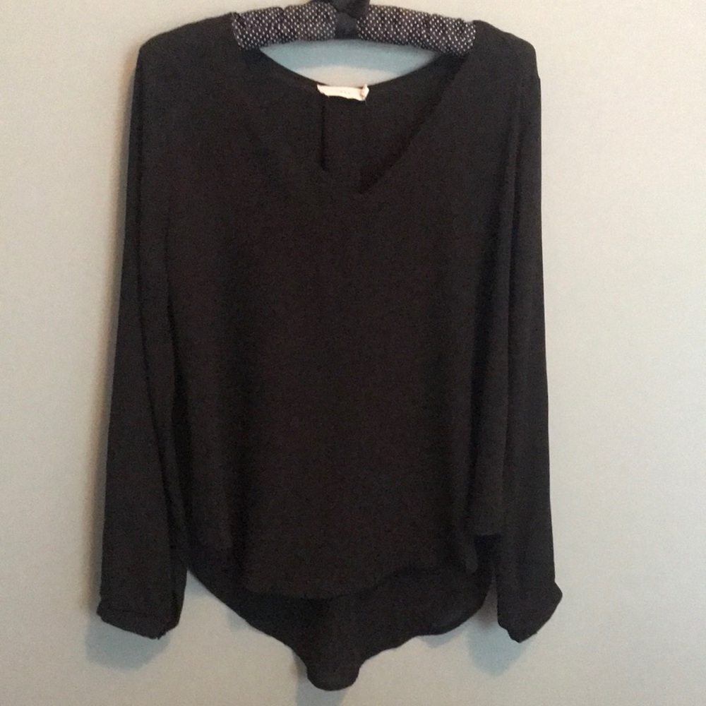 Lush black asymmetrical top with button cuff sleeves. Size: M